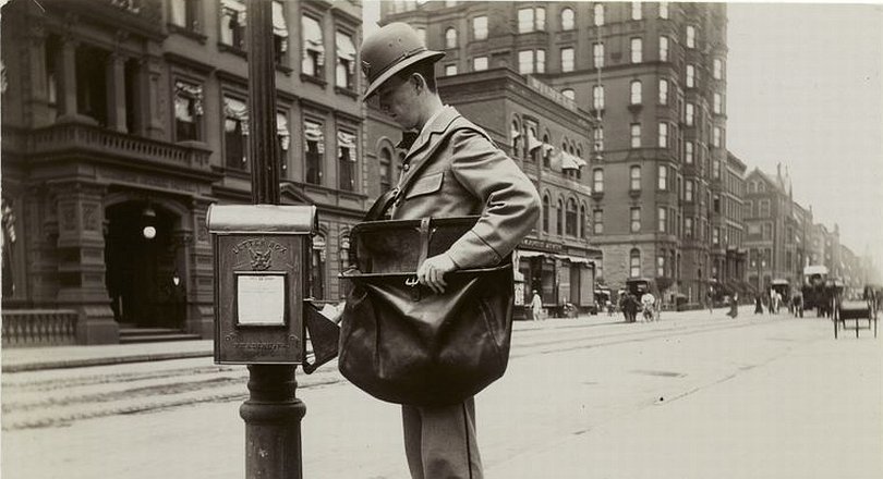Vintage photo of a postman at a letter box